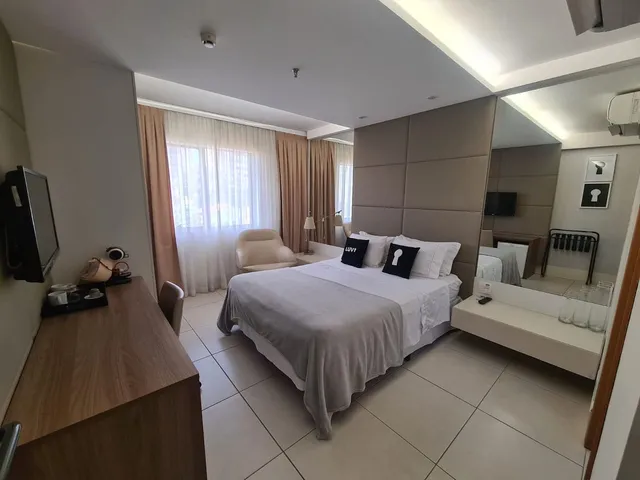 Corredor interno de galeria comercial com lojas e movimento de pessoas