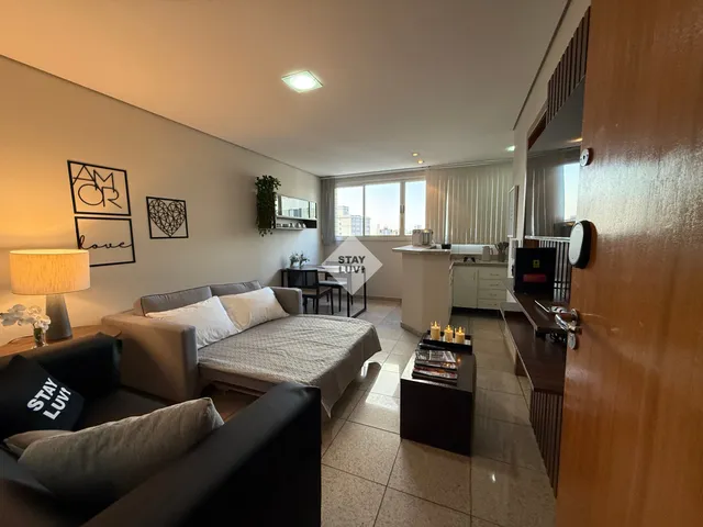 Casal olhando documentos em mesa com tablet e chaves de apartamento ao lado
