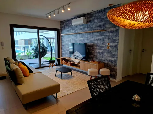 Executivo acomodado em apartamento mobiliado de médio prazo com mesa de trabalho e boa iluminação