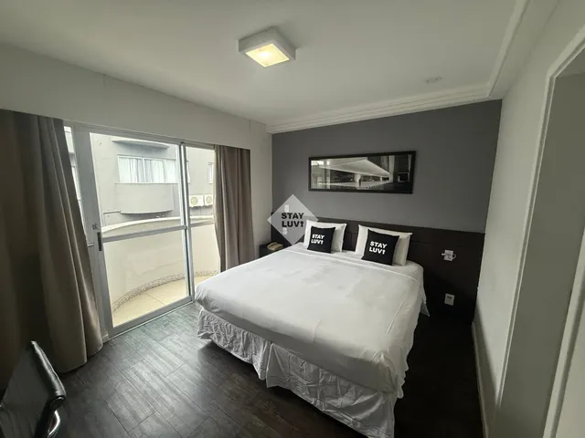 Cozinha moderna integrada à sala em apartamento bem decorado com iluminação natural