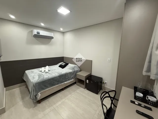Quarto de casal arrumado em apartamento mobiliado com roupa de cama branca