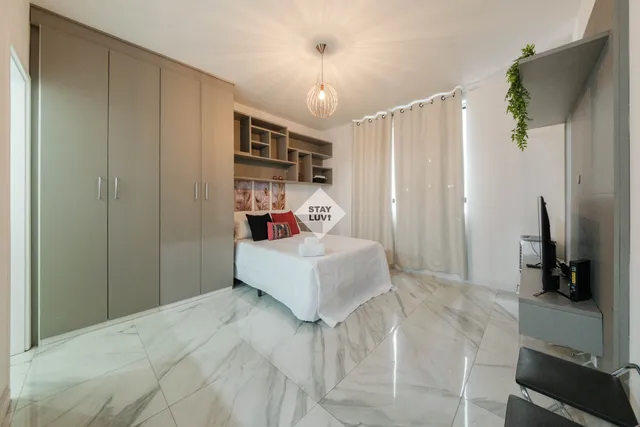 Cozinha compacta equipada de apartamento com fogão, geladeira, pia e utensílios organizados na bancada