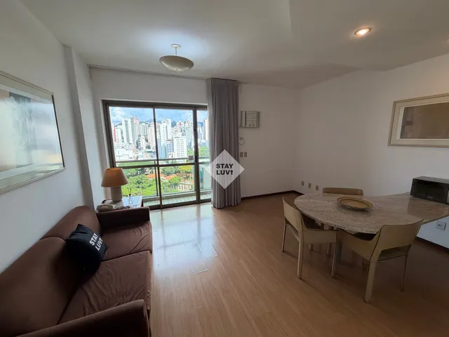 Cozinha renovada com bancada de pedra e armários brancos em apartamento para locação