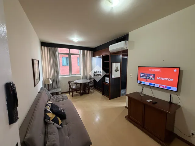 Pessoa analisando planilha de indicadores imobiliários em computador com gráficos na tela