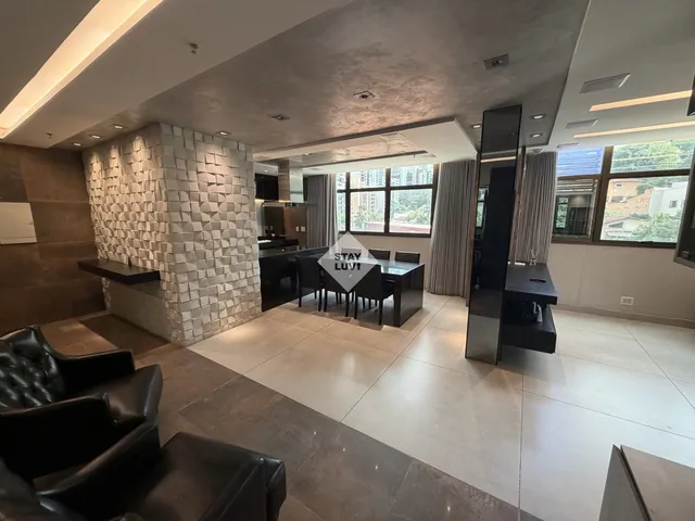 Área de convivência de coliving moderno com sofás, mesas de trabalho e luz natural abundante
